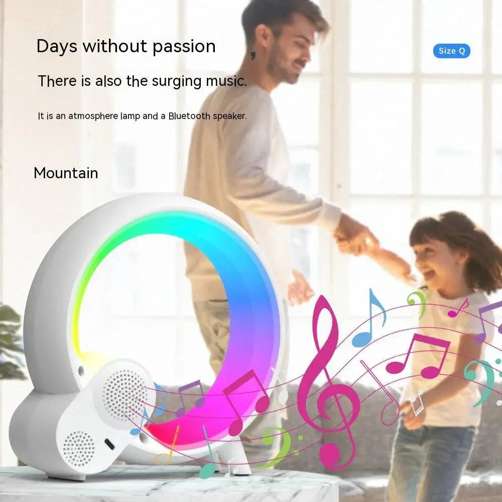 A sleek white circular q-light sunrise alarm clock with bluetooth speaker and glowing rainbow led atmosphere lamp