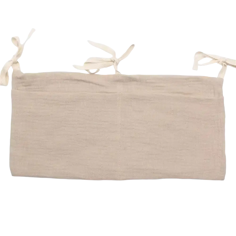 Beige linen crib storage bag diaper organizer showing tie-back with three tied fabric loops