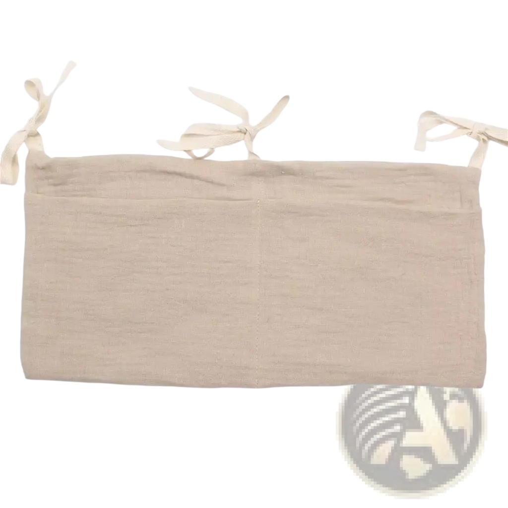 Beige linen crib storage bag diaper organizer showing tie-back with three tied fabric loops