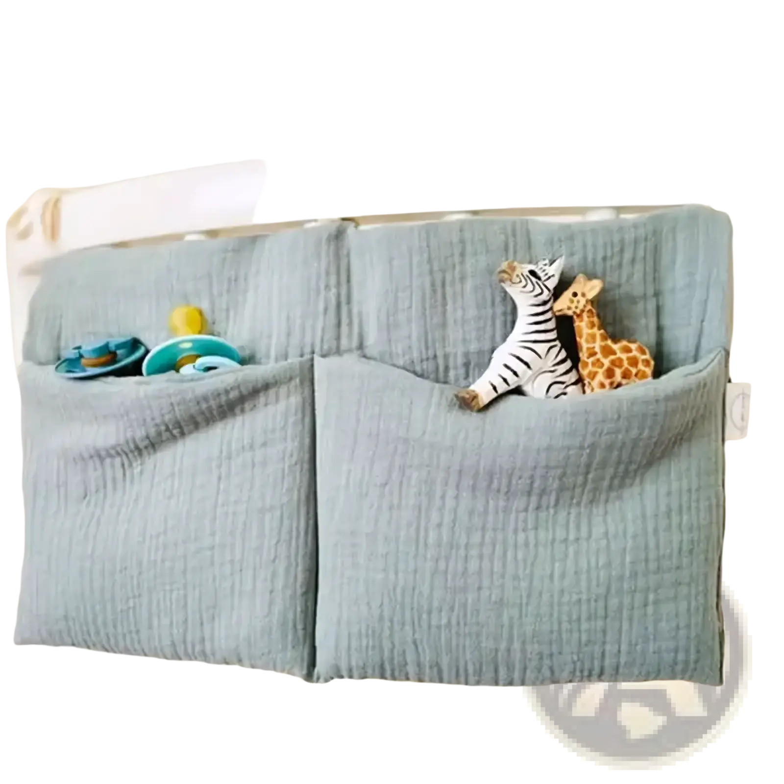 Light blue muslin crib storage bag diaper organizer with two pockets holding pacifiers and stuffed animal toys