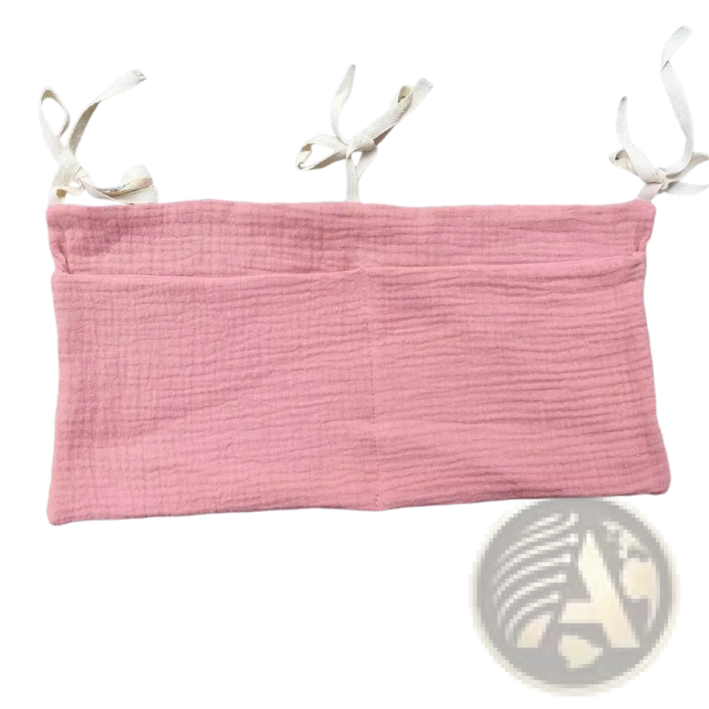 Soft pink textured cotton bandeau top with adjustable white fabric shoulder ties shown with crib storage bag diaper organizer