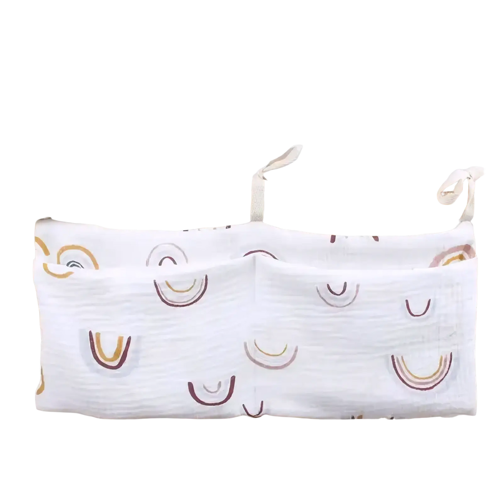 White cotton fabric crib storage bag diaper organizer with two pockets and soft gold and brown rainbow pattern