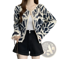 A navy blue and cream-colored crochet cardigan with intricate leaf-like floral patterns in a loose pullover design