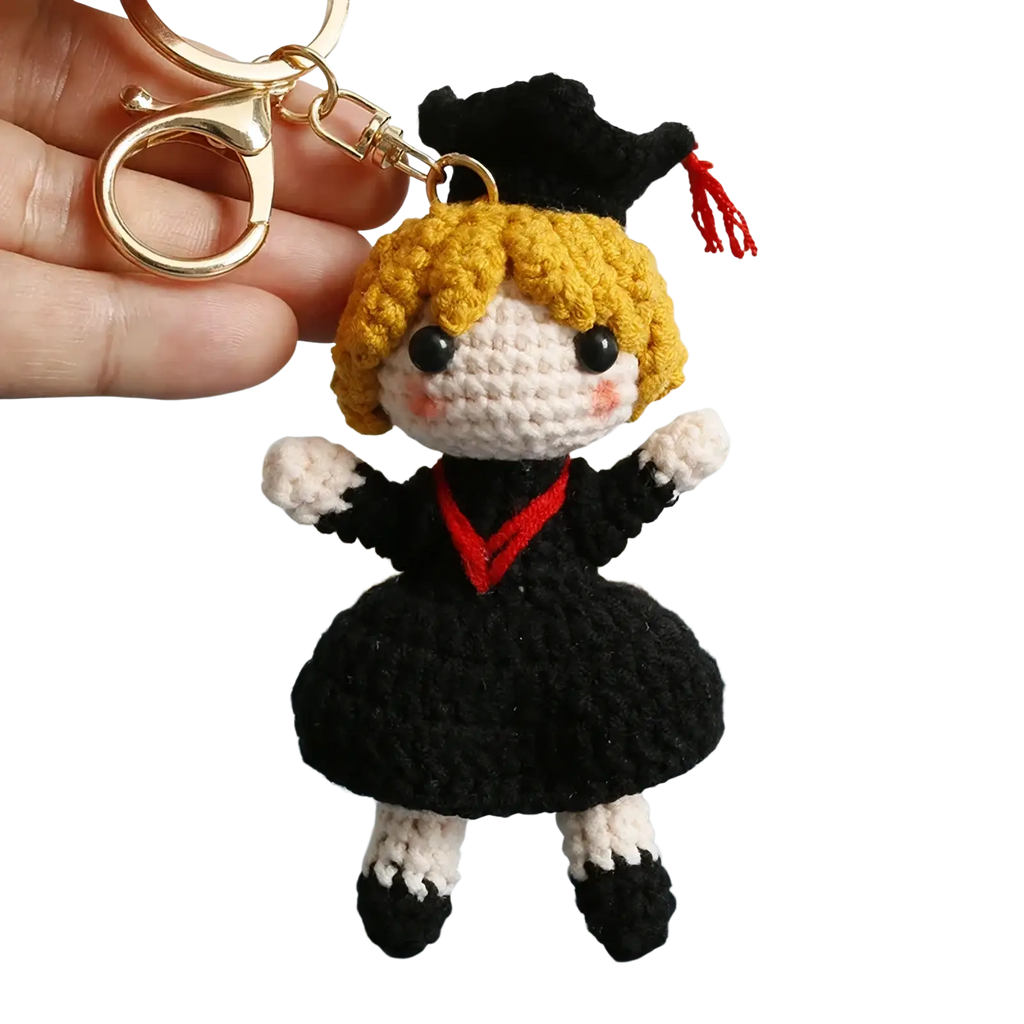 Crochet graduation doll keychain with blonde yarn hair black and white outfit red trim and black cap with red tassel