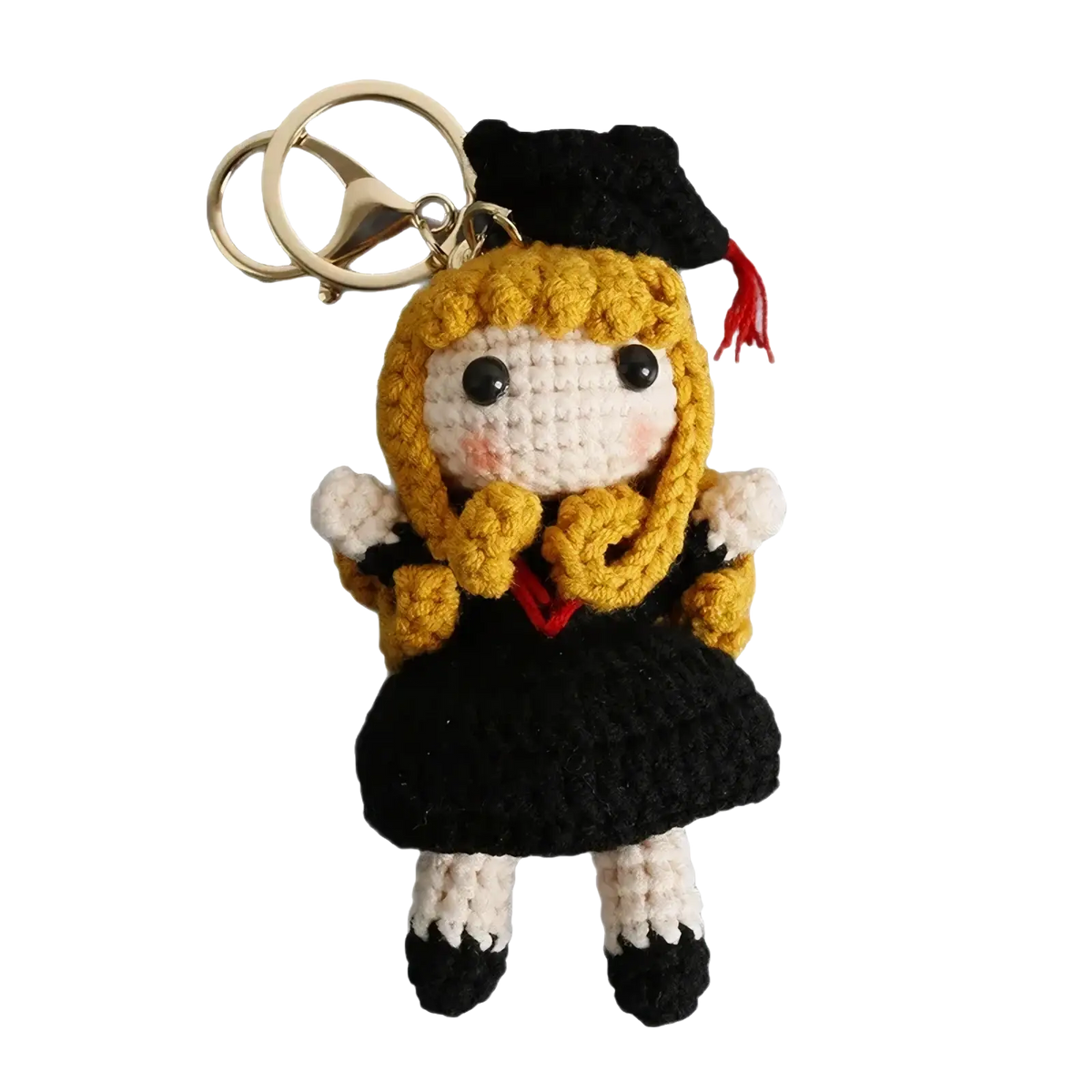 Crochet graduation doll keychain featuring golden yarn hair, black cap and gown, and white face with rosy cheeks