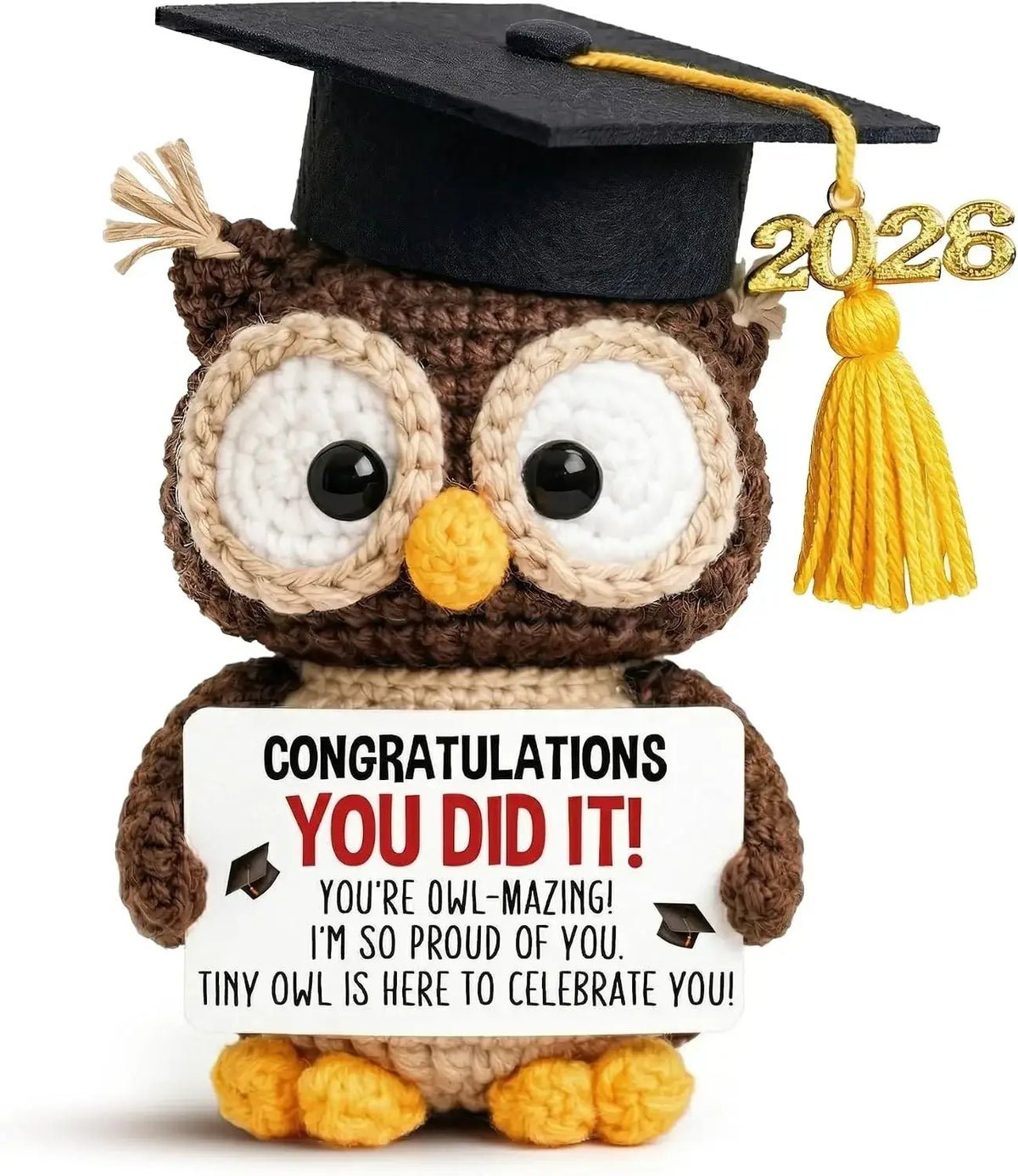 A brown crocheted owl graduation keepsake wearing a black cap with yellow tassel holding a congratulations sign