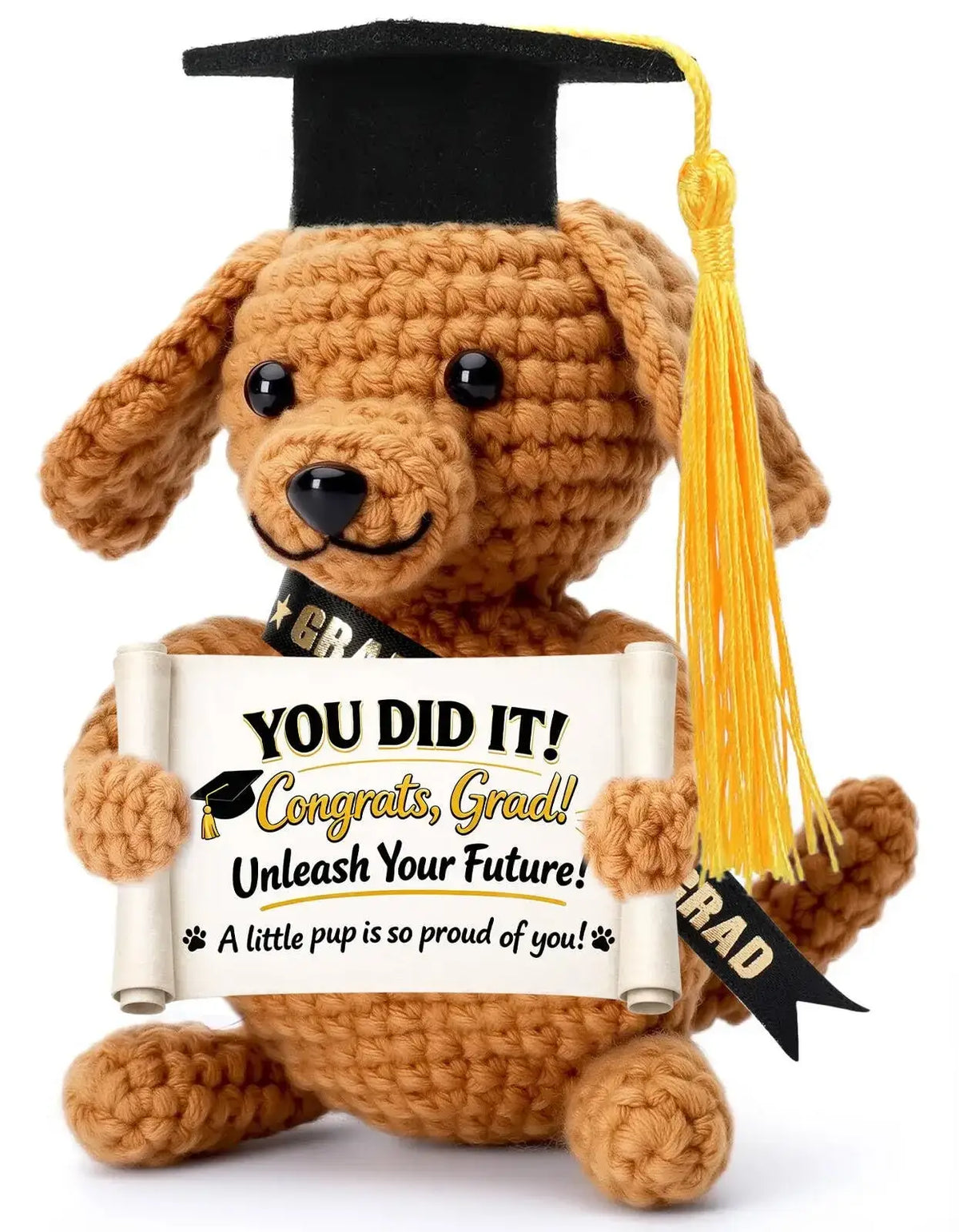 A tan crocheted puppy pocket hug keepsake wearing a black graduation cap and holding a you did it congrats grad scroll