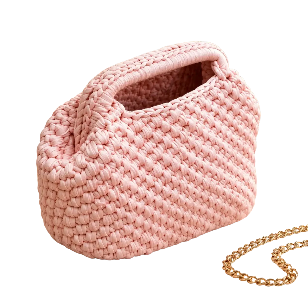 A soft pink chunky-knit crocheted shoulder bag with rounded shape and integrated handles for beach vacations