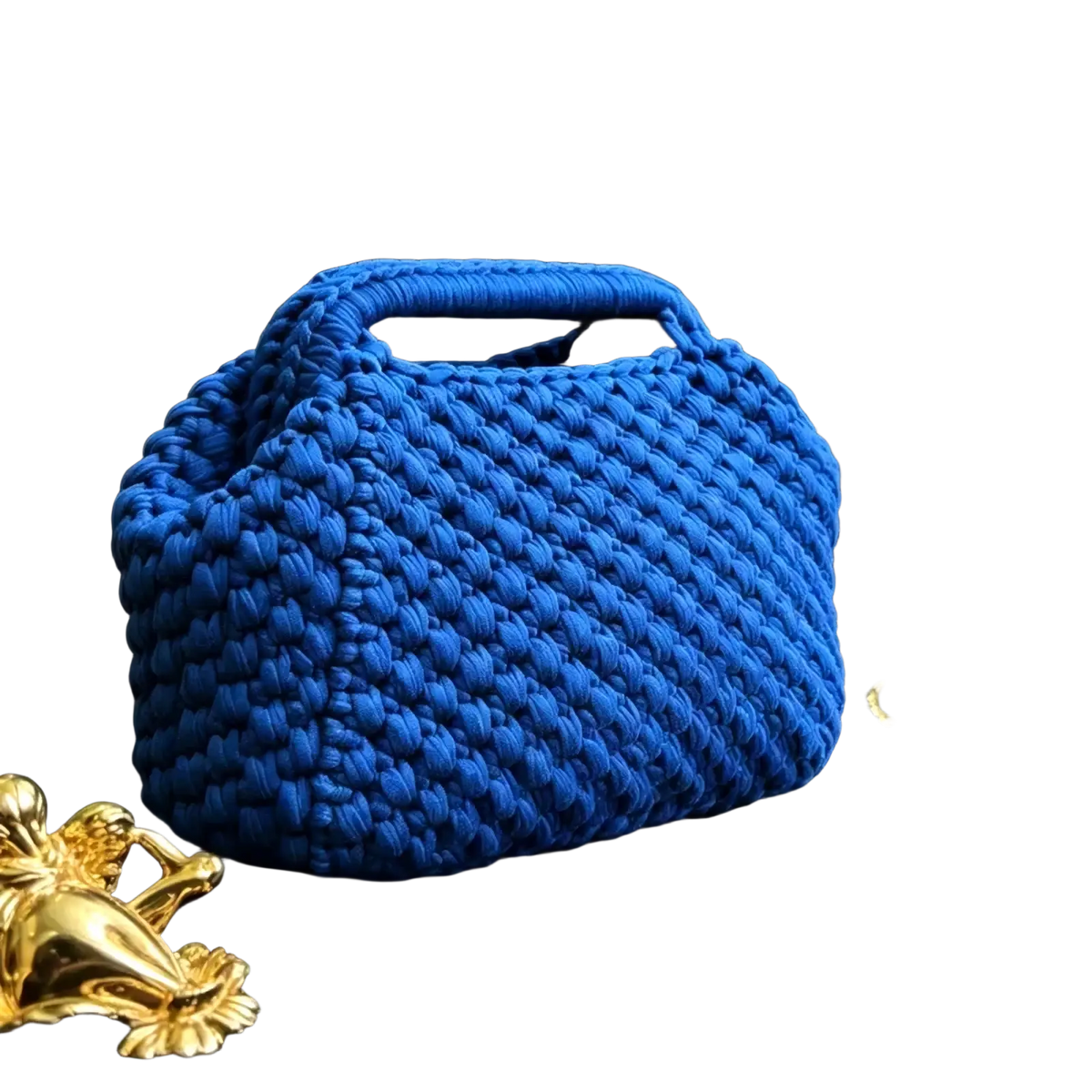 A vibrant cobalt blue crocheted shoulder bag with chunky knit texture and integrated top handle for beach vacation use