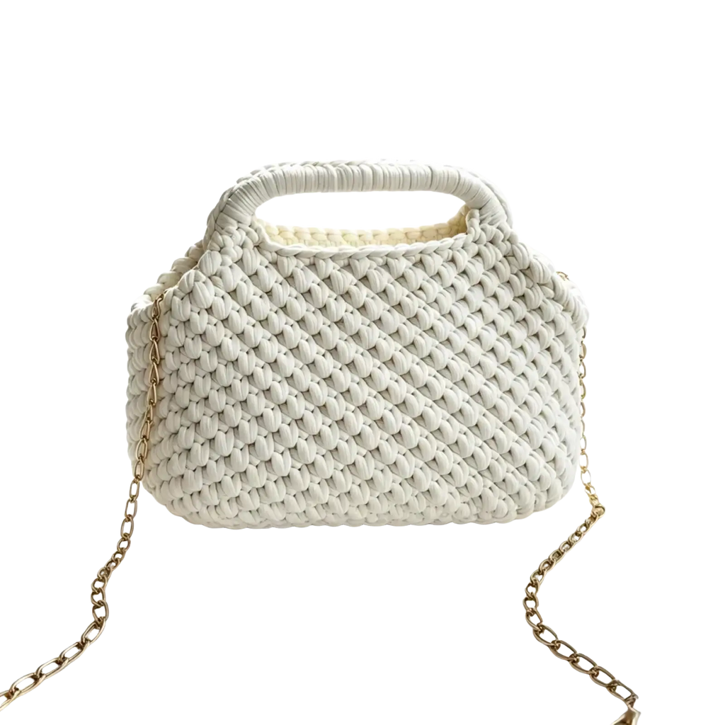 A white crocheted knitted shoulder bag with textured woven pattern and gold toned chain strap for beach vacation tote