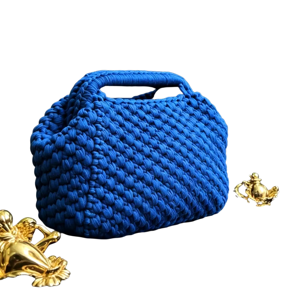 A vibrant royal blue crocheted shoulder bag with chunky knit texture and integrated top handle for beach use