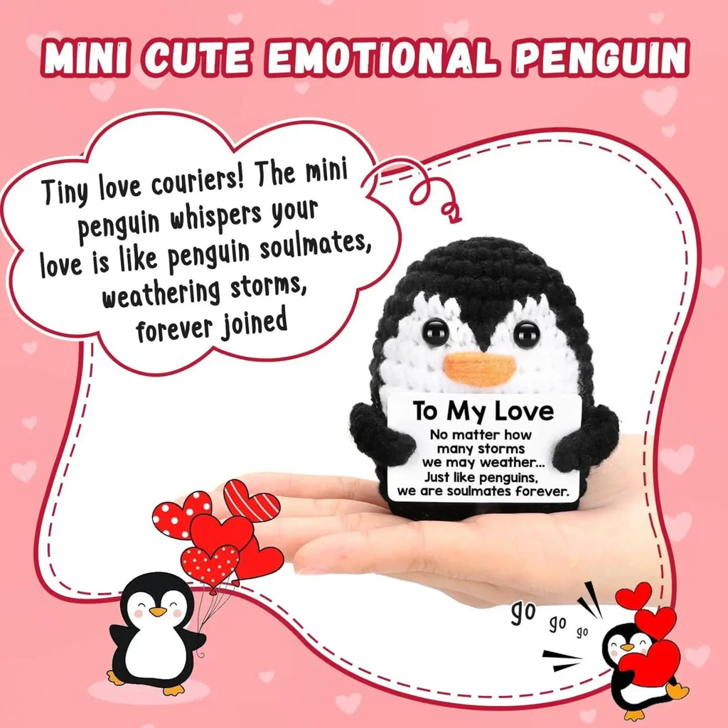 Black and white crocheted penguin with orange beak holding a card to my love in crocheted penguin love gift