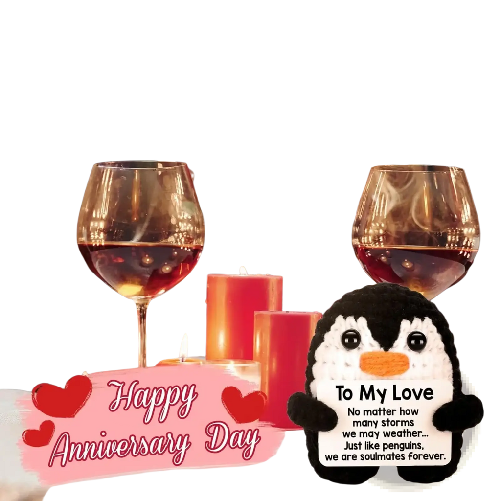 Black and white crocheted plush penguin figurine with orange beak holding a love card for romantic gift