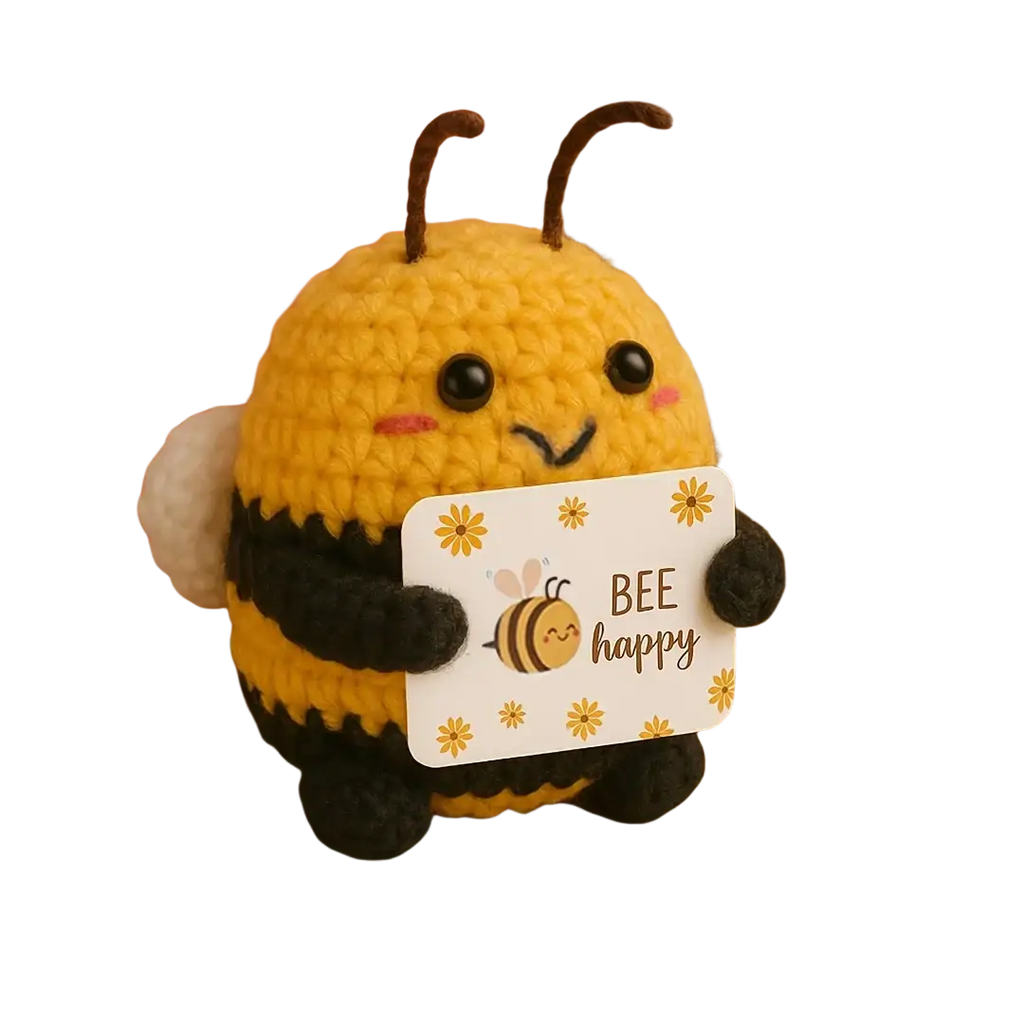 A yellow and black crocheted bee plush toy holding a bee happy card as a keychain and bag charm