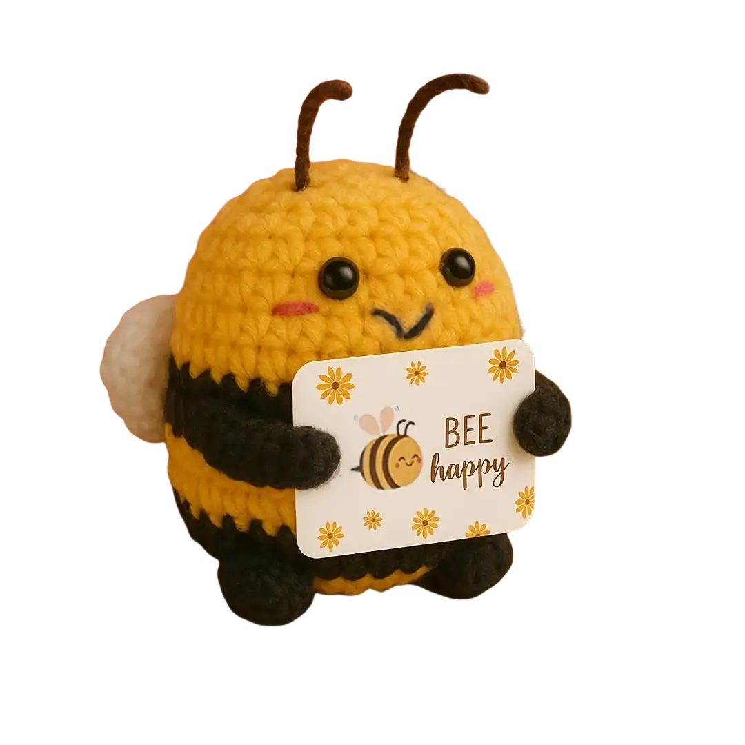 A yellow and black crocheted bee plush toy holding a bee happy card as a keychain and bag charm