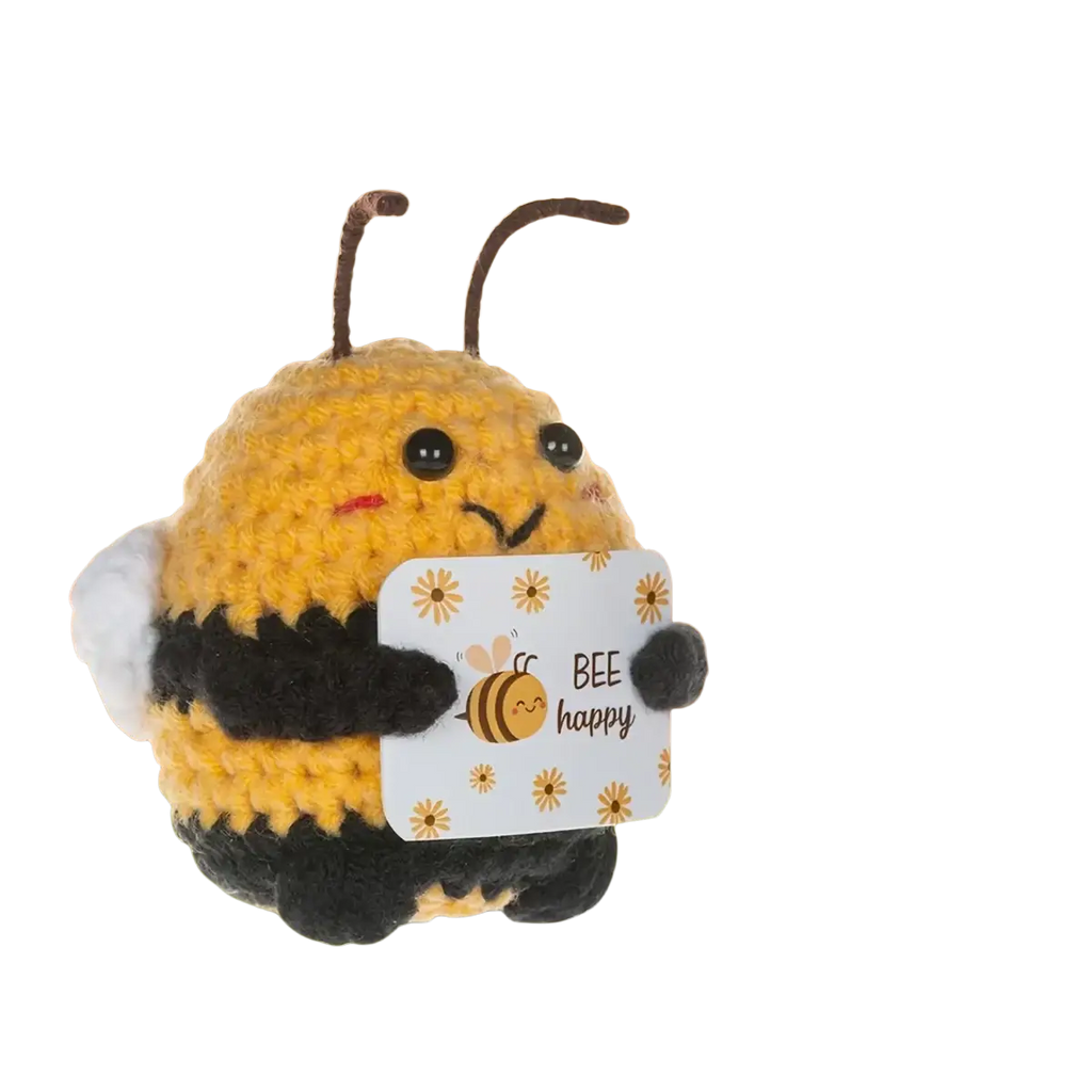 A yellow and black handwoven crocheted bee plush toy holding a bee happy sign as a keychain and bag charm