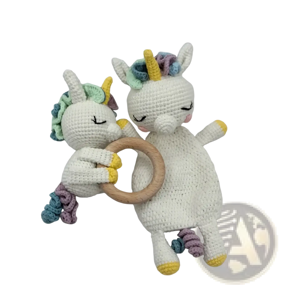 Two crocheted unicorn baby comforter rattles with white bodies pastel yarn manes tails and a wooden ring handle