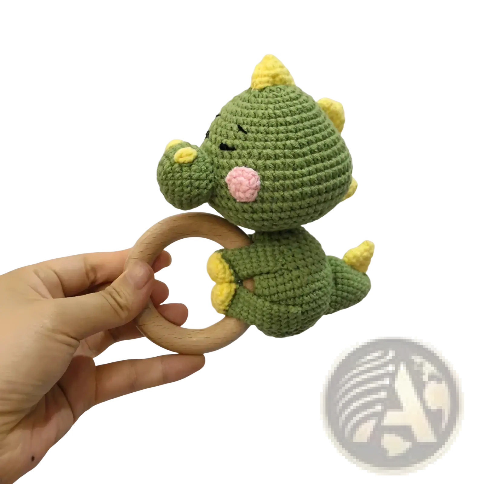 Crocheted unicorn baby comforter security blanket featuring a green crocheted dinosaur rattle with yellow spikes and pink nose attached to a wooden ring