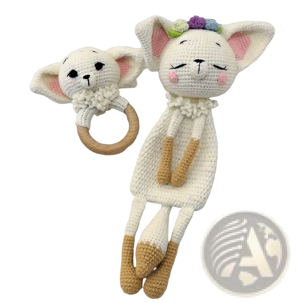 A white crocheted cat rattle with pink ears and floral crown paired with a crocheted unicorn baby comforter blanket