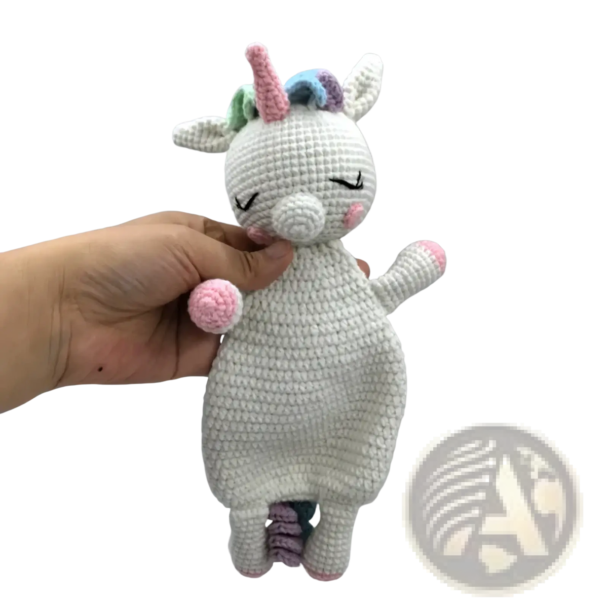 A soft white crocheted unicorn baby comforter security blanket with pink accents and a colorful rainbow mane
