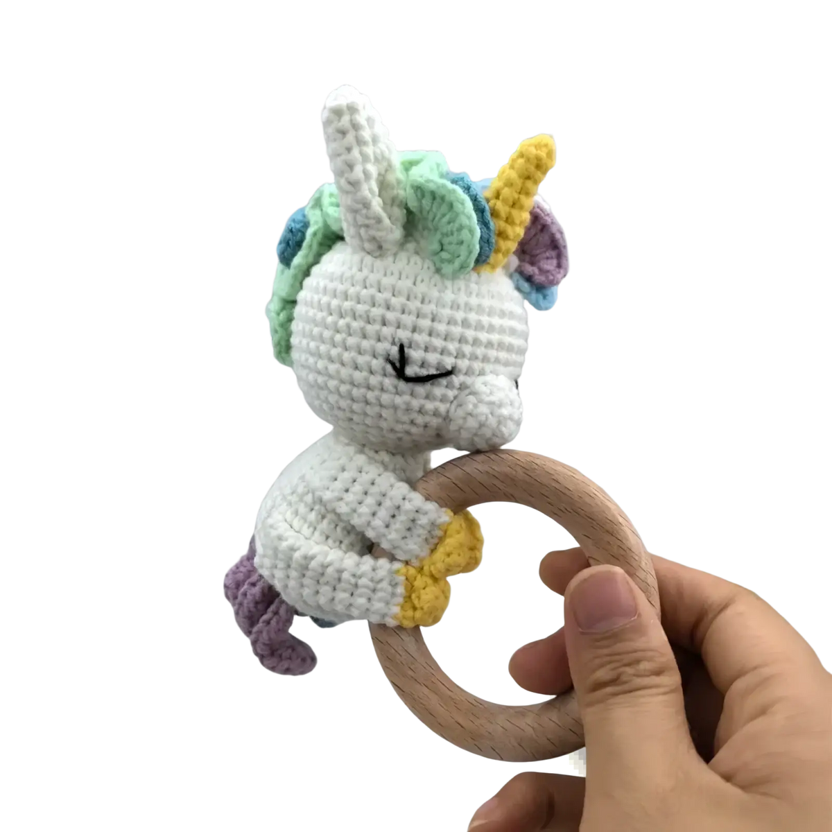 Crocheted unicorn baby comforter security blanket with white body rainbow mane horn tail holding natural wood ring