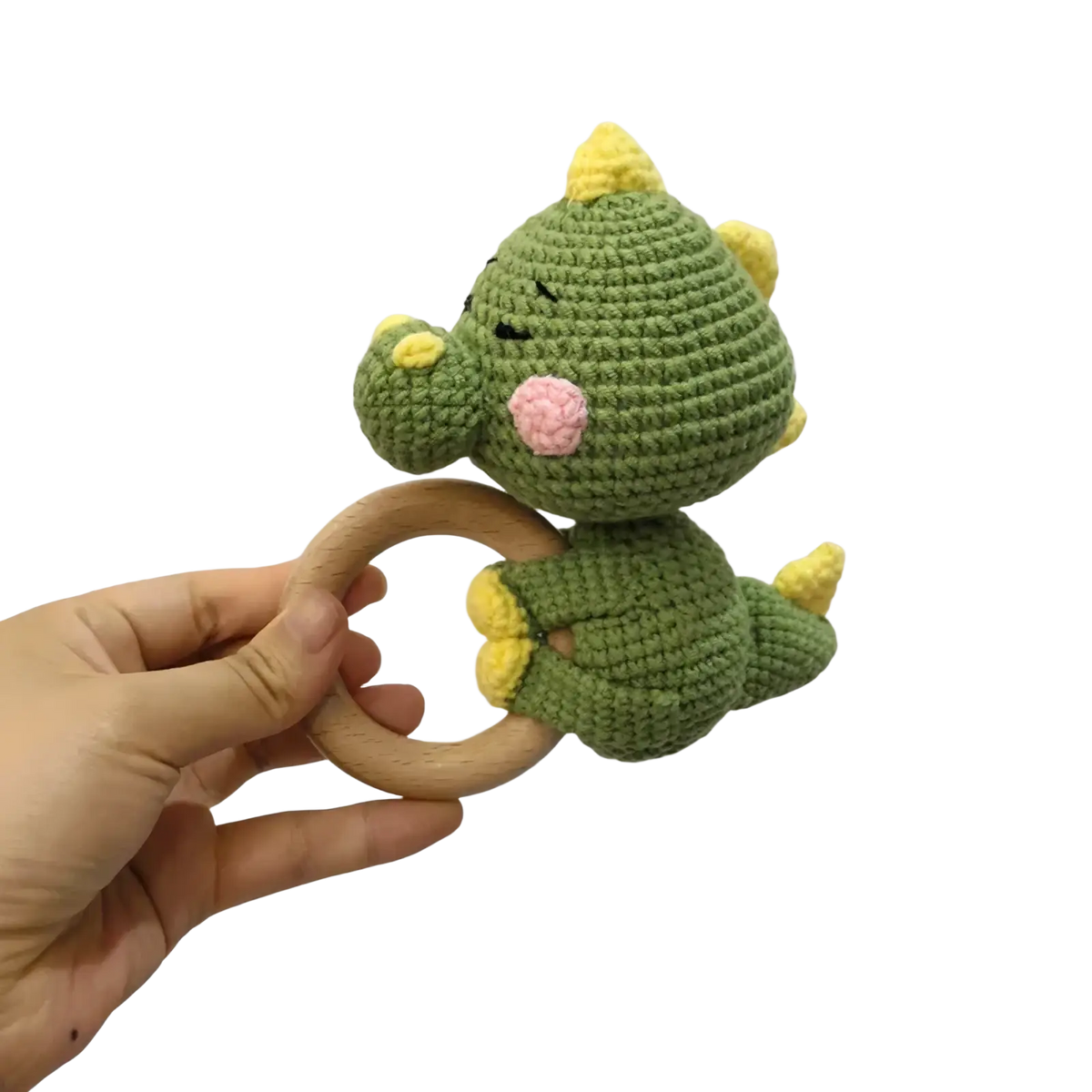 Crocheted unicorn baby comforter security blanket featuring a green crocheted dinosaur rattle with yellow spikes and pink nose attached to a wooden ring