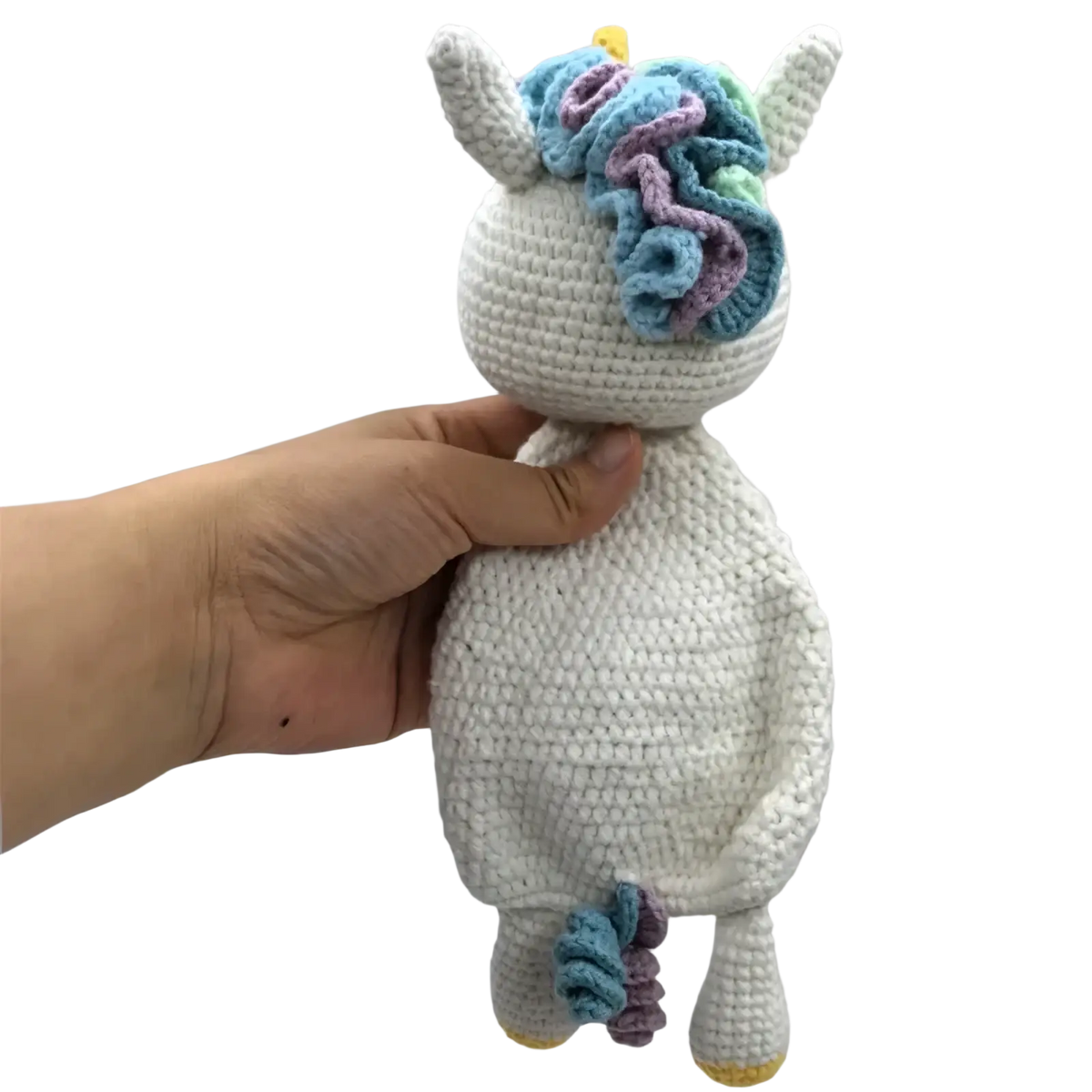 A soft white crocheted unicorn baby comforter with colorful blue and purple yarn mane yellow horn and hooves