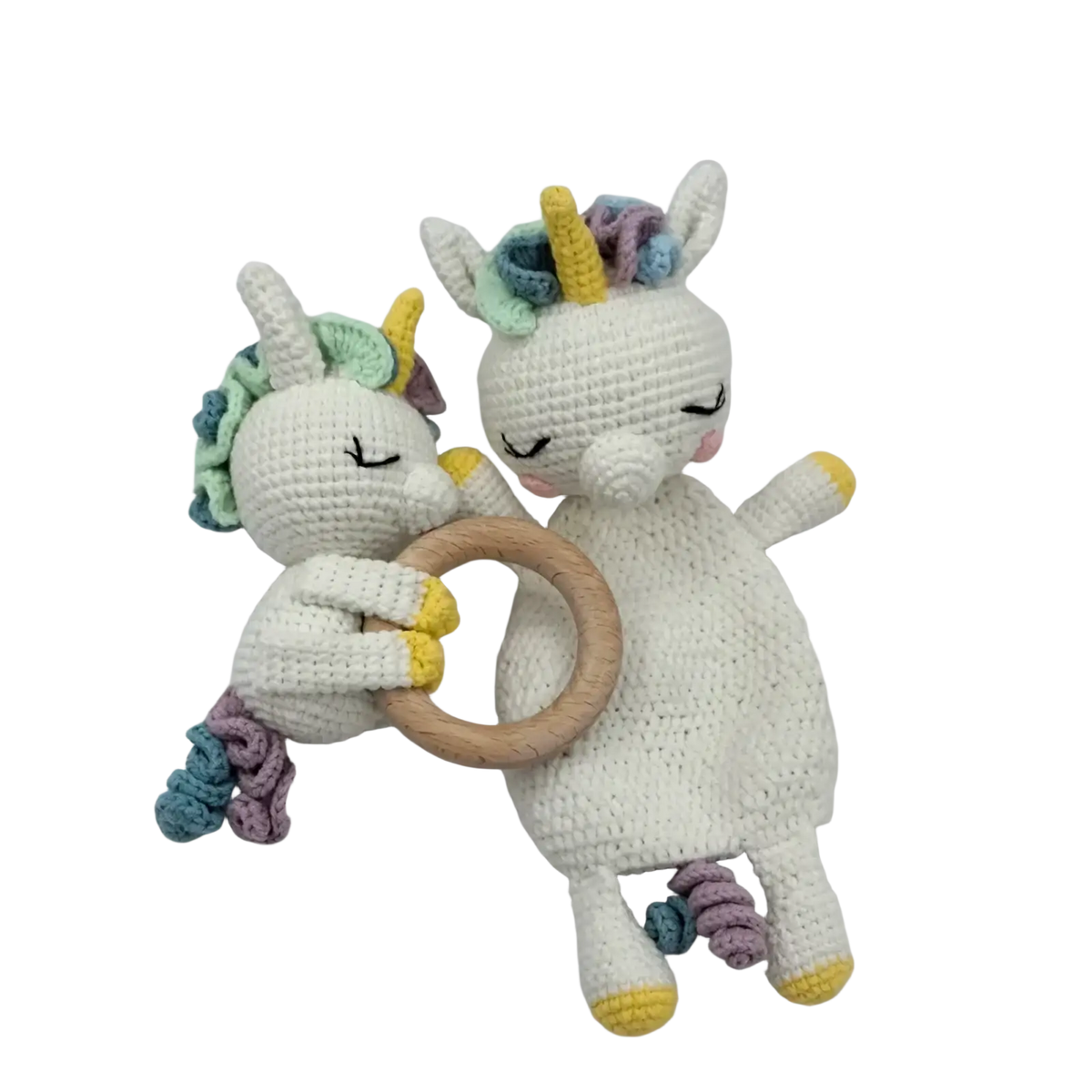 Two crocheted unicorn baby comforter rattles with white bodies pastel yarn manes tails and a wooden ring handle
