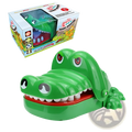 Green plastic crocodile biting finger game toy with white teeth and red interior for interactive kids entertainment