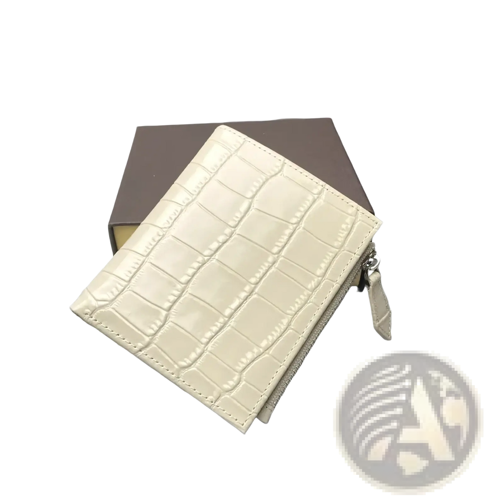 Cream-colored crocodile-embossed leather unisex wallet with zipper closure and matching pull tab