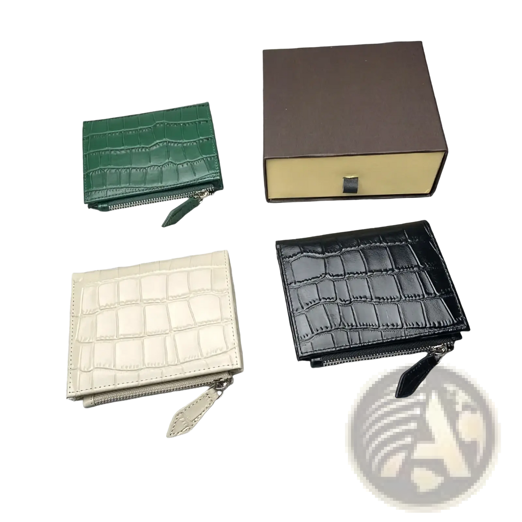 Three compact unisex crocodile leather wallets in green cream and black with zipper closures