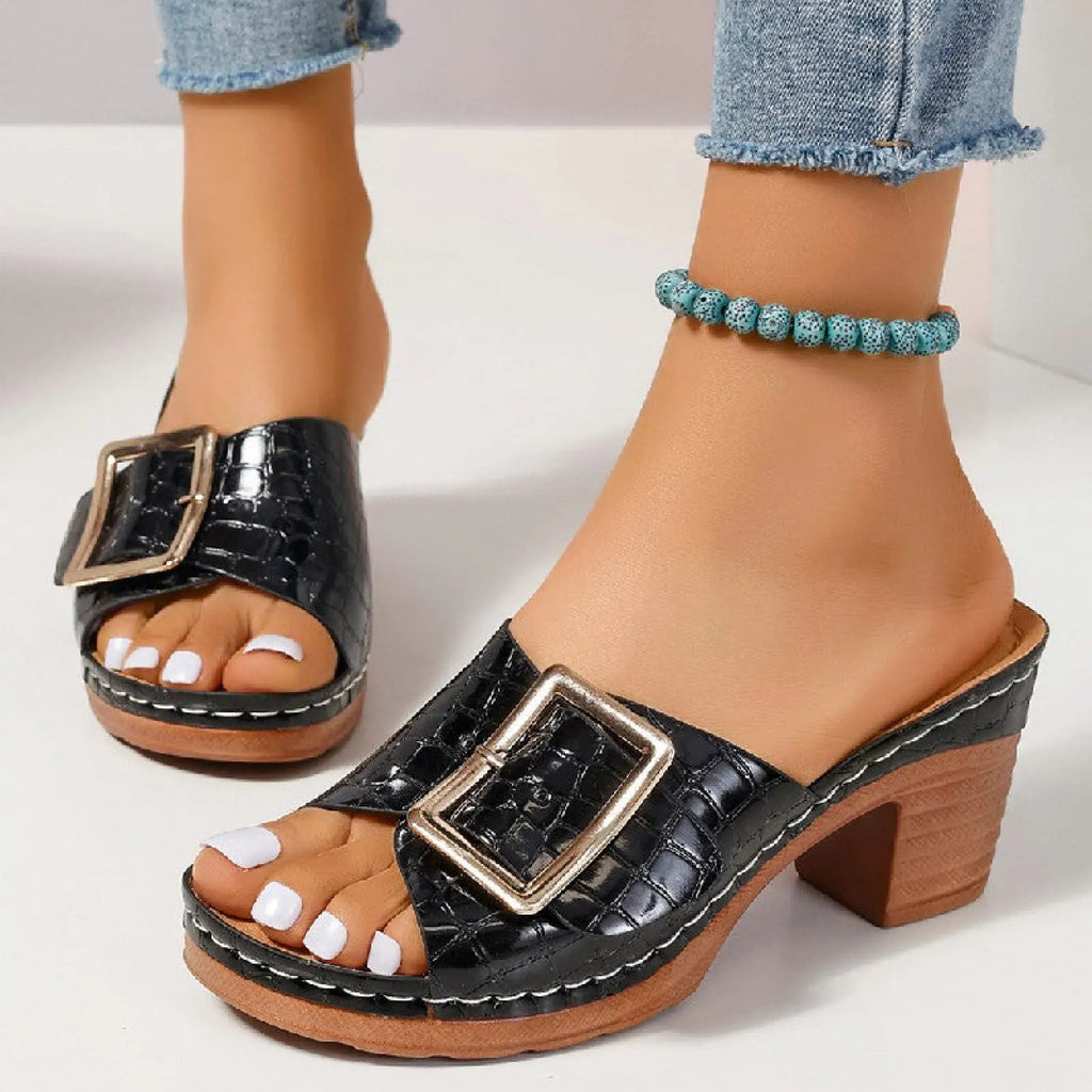 Black croc-embossed leather mule sandals with a gold-tone rectangular buckle and wooden block heel peep toe design