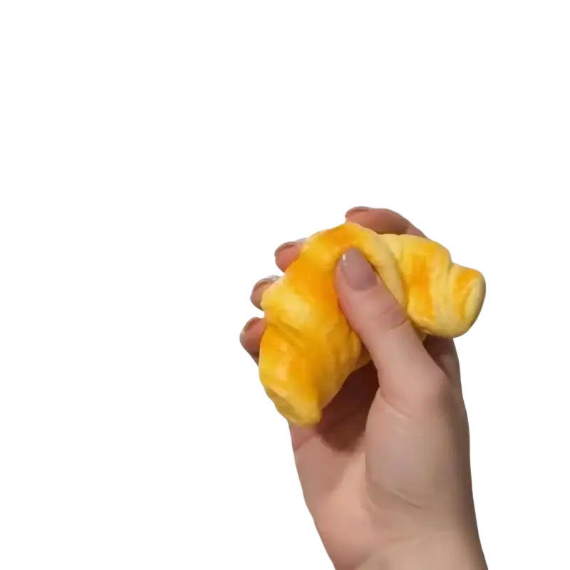 A yellow plush croissant squeeze toy stress relief bread held in hand as a soft croissant squeeze toy stress ball