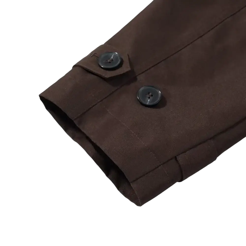 Dark brown fabric sleeve with two black buttons on a cropped brown trench coat women casual outerwear item