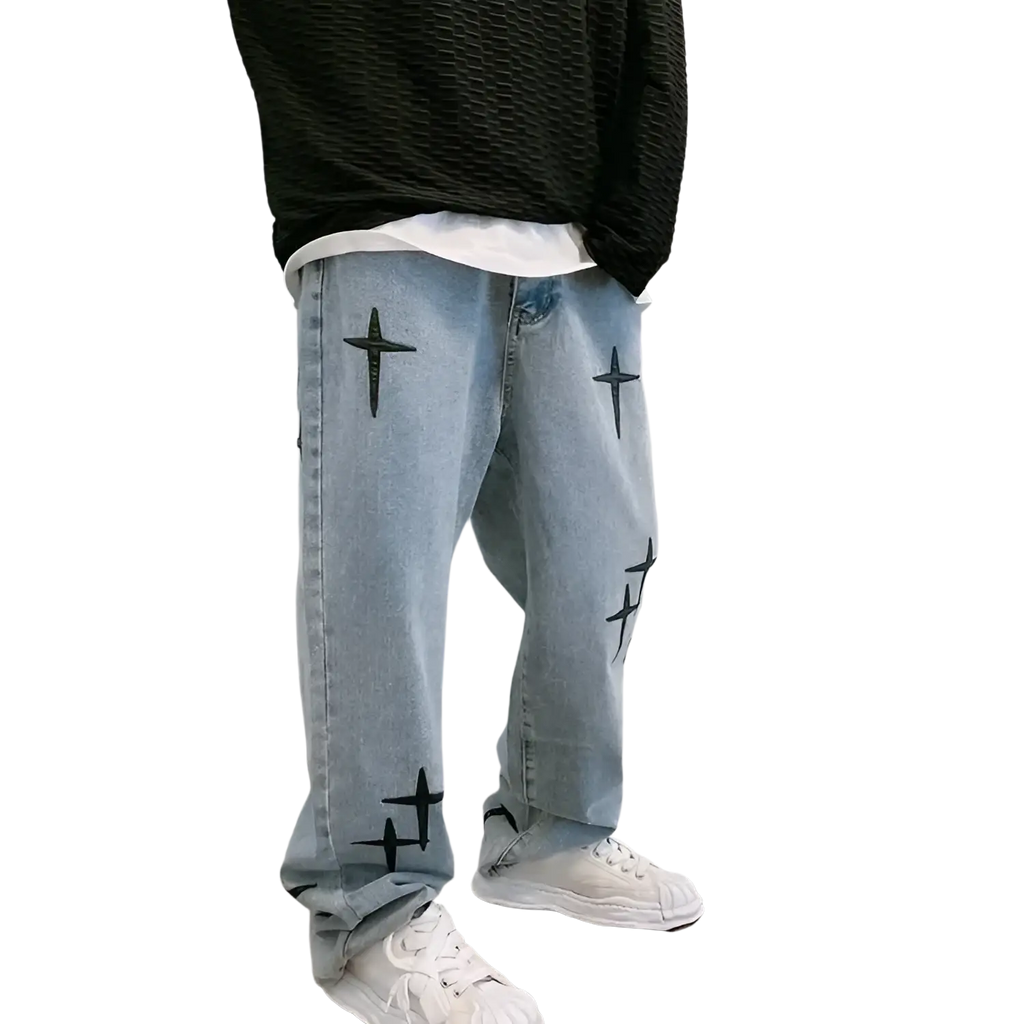Light-wash denim baggy wide leg jeans with black cross embroidery on the legs in a front view