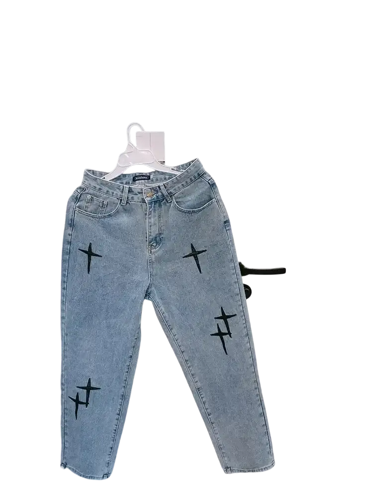 Light-wash denim baggy wide leg jeans with black cross embroidery on the legs in front view