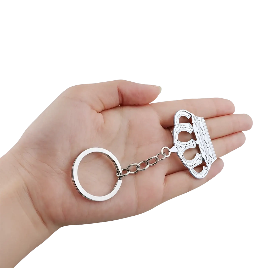 Silver metallic crown-shaped keychain with intricate detailing and chain link attached to a circular ring