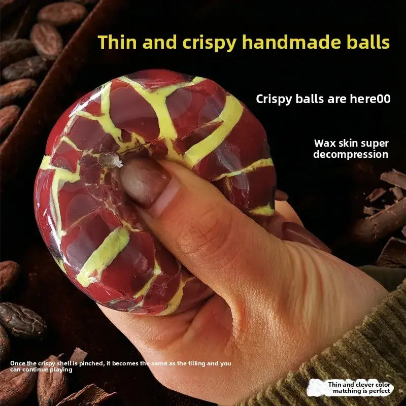 A glossy red and yellow cracked candy ball with wax skin coating used as a crunchy stress ball sensory fidget toy blue