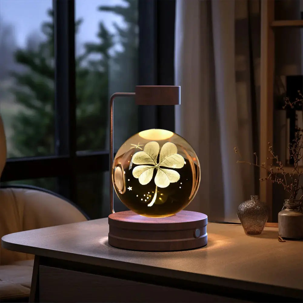 A warm glowing 3d crystal ball dinosaur night light usb lamp with clear glass and illuminated four-leaf clover design