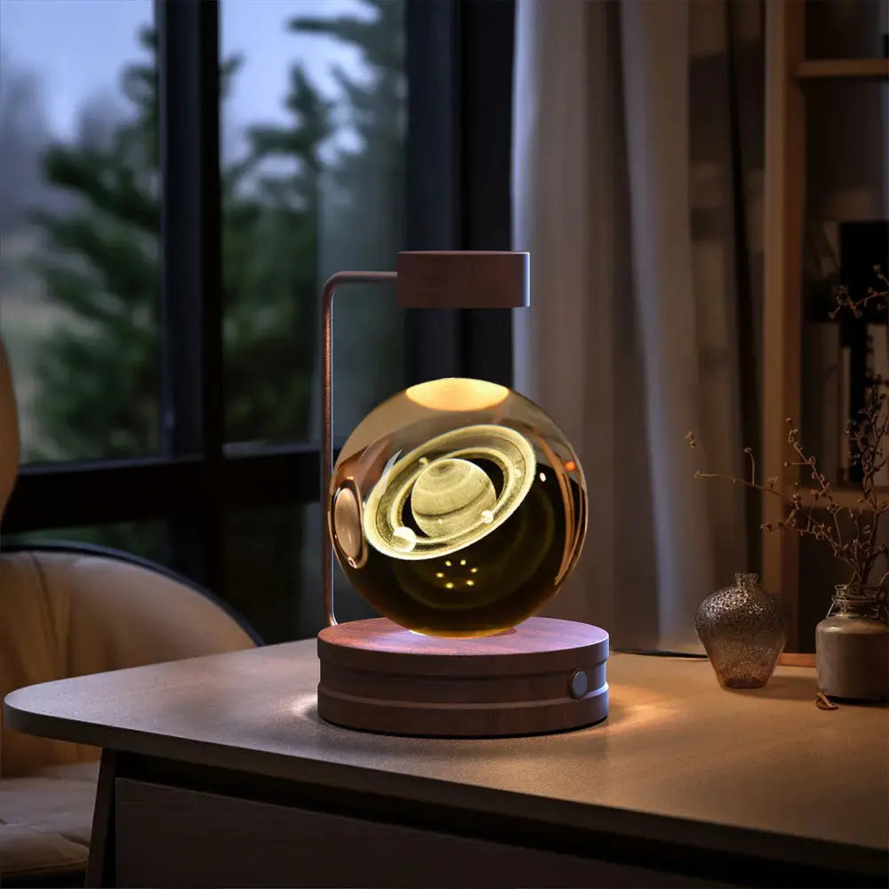 3d crystal ball dinosaur night light with a golden saturn design inside a glass sphere on a wooden base