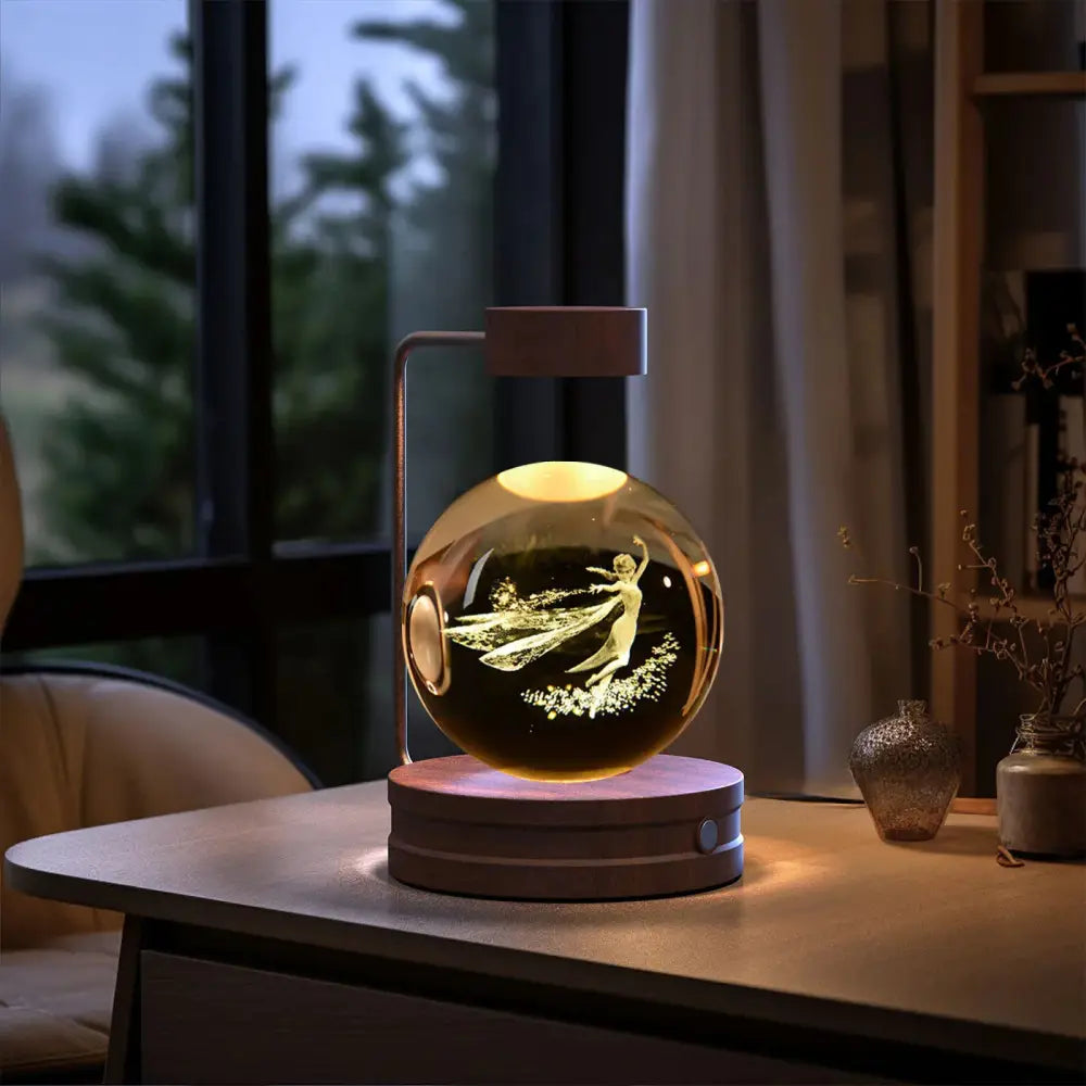 A glowing 3d crystal ball dinosaur night light usb bedside lamp with etched fairy design on a metallic stand