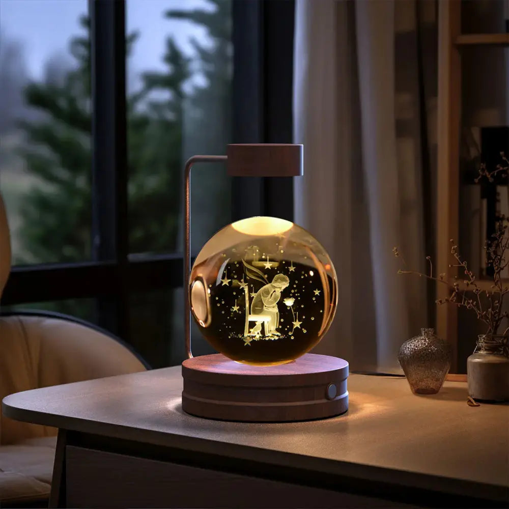 A warm-toned spherical led 3d crystal ball night light with an engraved little prince scene inside a glass dome