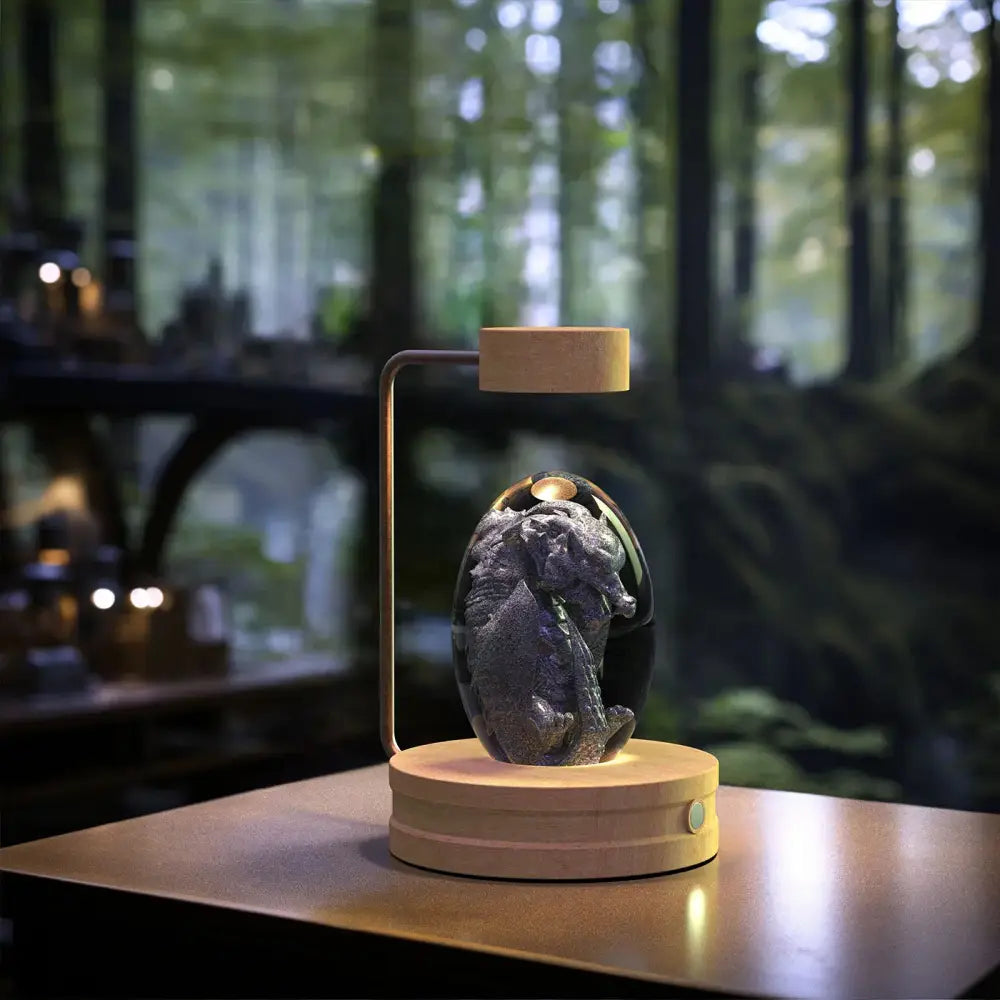 A sleek dark gray dragon figurine inside a transparent dome with led light on wooden base usb night lamp