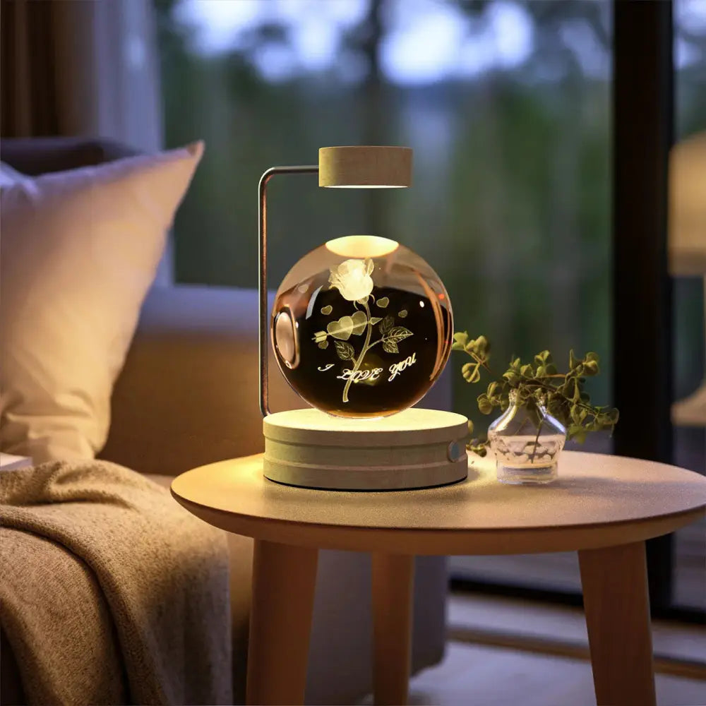 A sleek spherical glass 3d crystal ball dinosaur night light with engraved rose design and warm glow on white base
