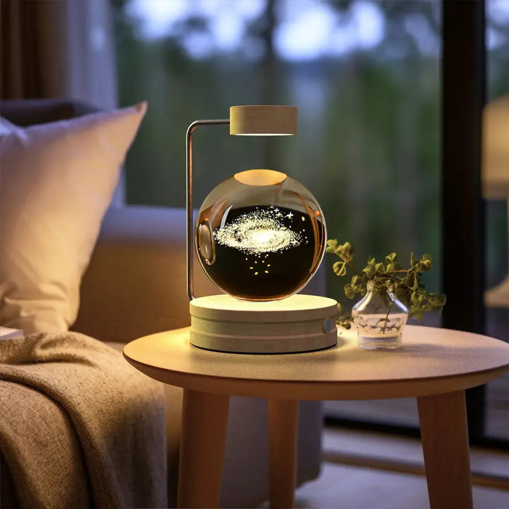 A sleek spherical 3d crystal ball dinosaur night light with a glowing galaxy design inside a glass dome