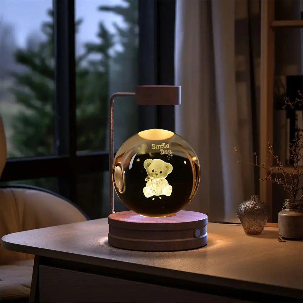 A 3d crystal ball dinosaur night light with a glowing glass globe featuring a teddy bear design on a dark brown base