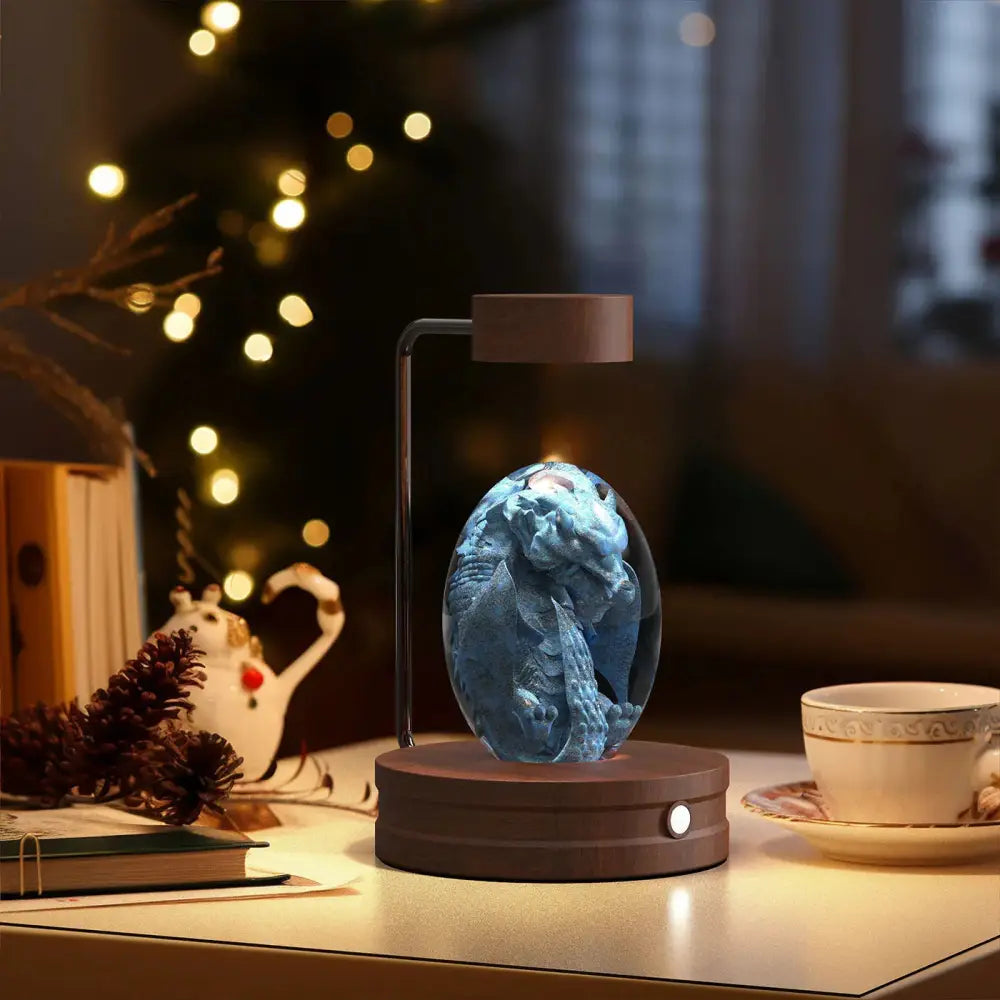 A glowing blue dragon figurine suspended by a magnetic base inside a 3d crystal ball dinosaur night light usb lamp
