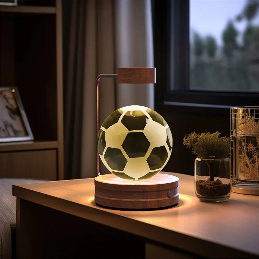 Floating soccer ball lamp with classic black and white panels illuminated by warm led light for bedside use
