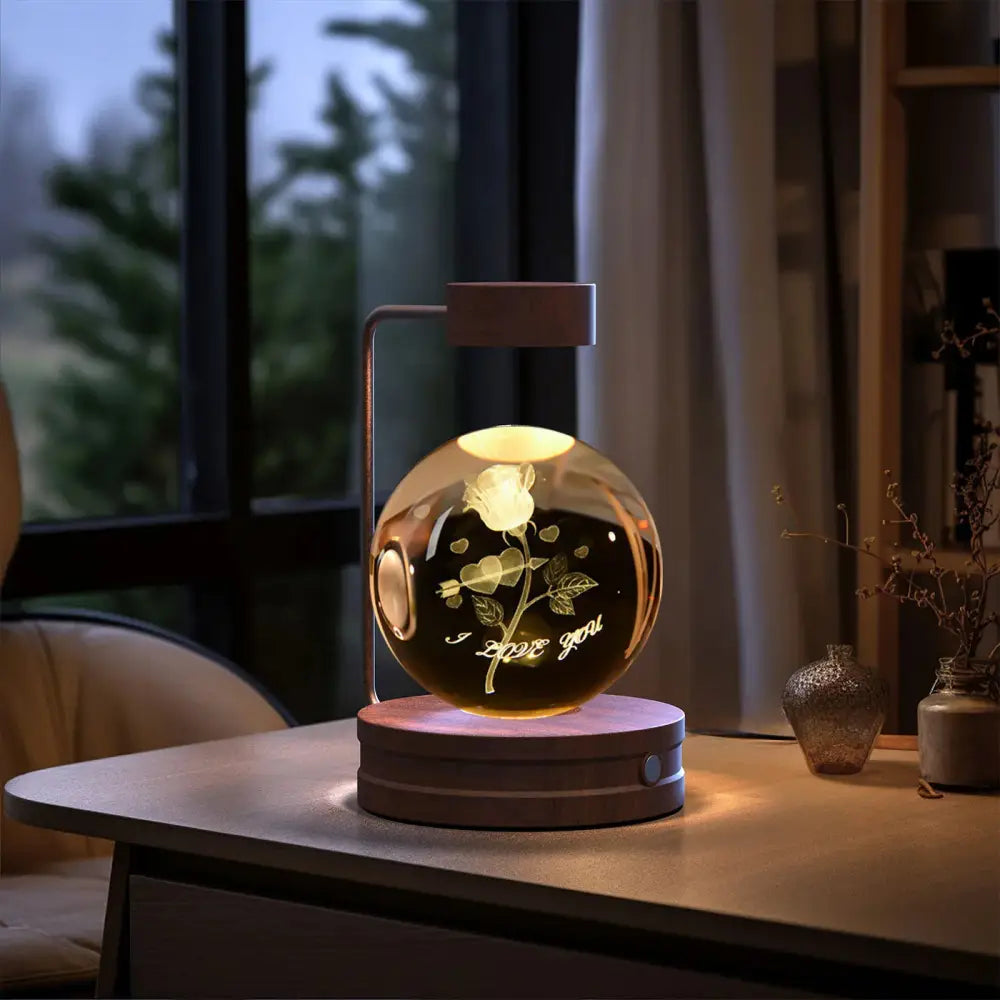 A glowing spherical glass lamp engraved with a rose and i love you inscription illuminated by warm light usb bedside lamp