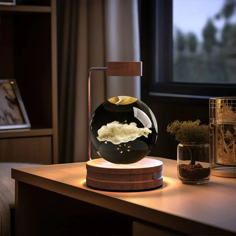 Floating black spherical 3d crystal ball dinosaur night light with gold accents on wooden base using magnetic levitation